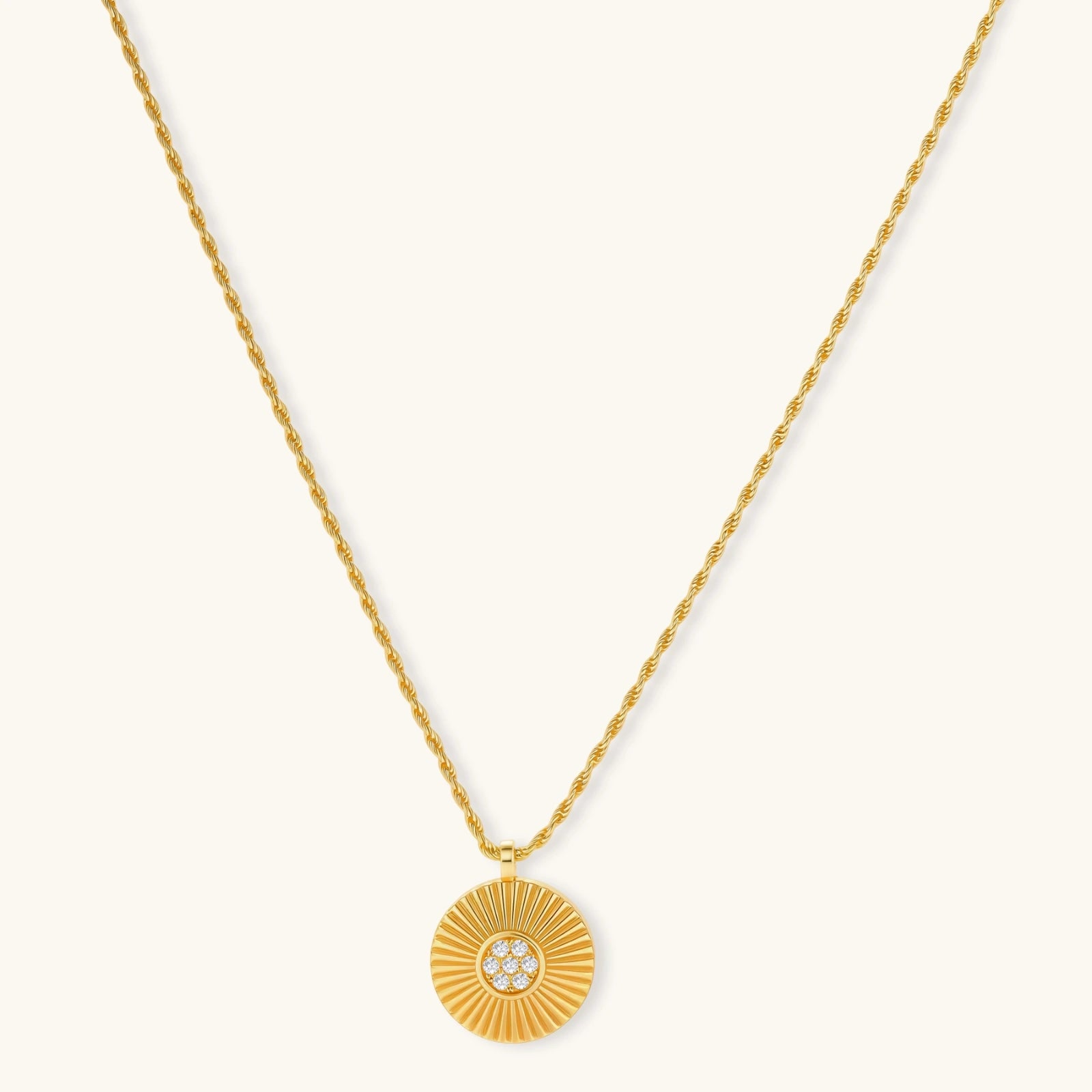 Gold-plated sterling silver necklace with sunburst pendant featuring radiating lines and cubic zirconia center stones